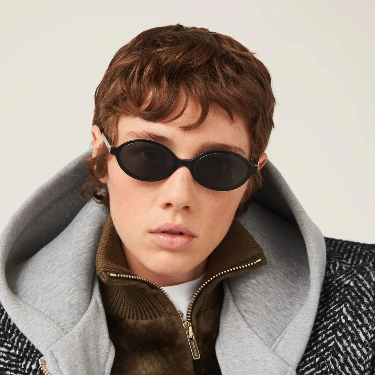 "Top-down shot of women's Miu Miu sunglasses SMU 04Z 1AB 5S0, blending bold oval styling with classic black frames for women at optorium."